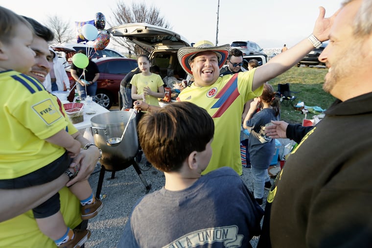 Rubén Vásquez (center) greets friends as he prepares a homemade sancocho during a La Unión Latina tailgate prior to the FC Dallas vs. Union MLS match at Talen Energy Stadium in April.