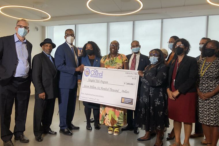 Government officials, a Philadelphia homeowner, and representatives from social services and legal aid organizations celebrate the allocation of $7.6 million in city funds to help residents clear tangled titles during a news conference in September.