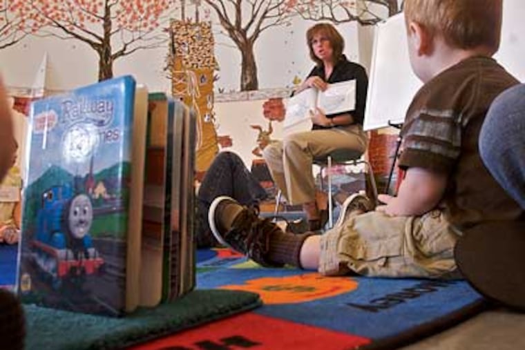 At the Cherry Hill Public Library, part-time librarian Kristen Redmond puts plenty of drama into her reading of "The Pigeon Wants a Puppy!" (John Costello / Inquirer)