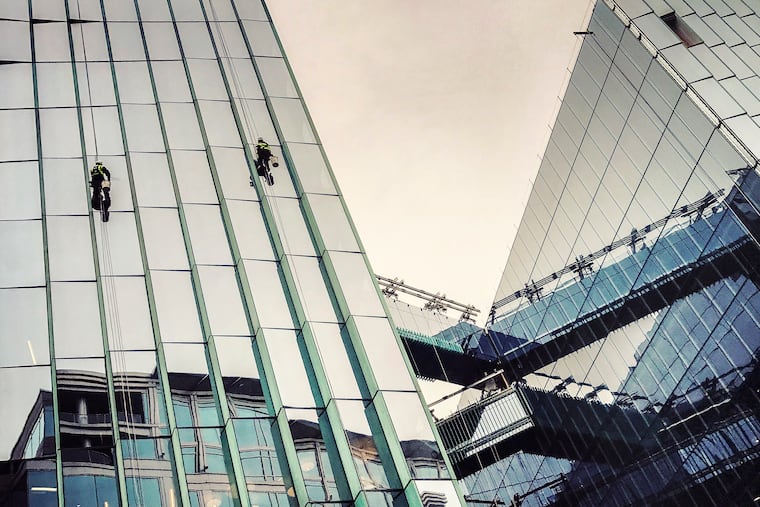 Workers clean the glass sides of the Fannie Mae headquarters in Washington. Washington Post photo by Bill O'Leary