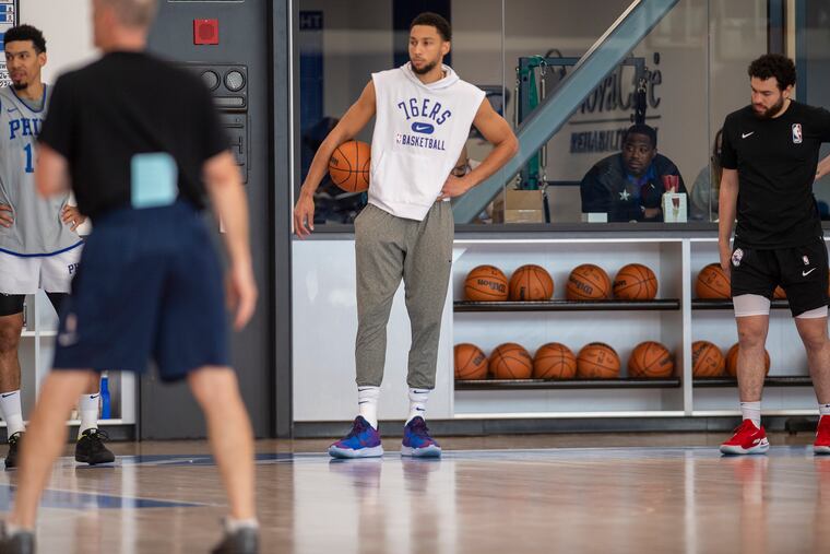 Ben Simmons, center, looks on during practice Monday at the Sixers' practice facility.