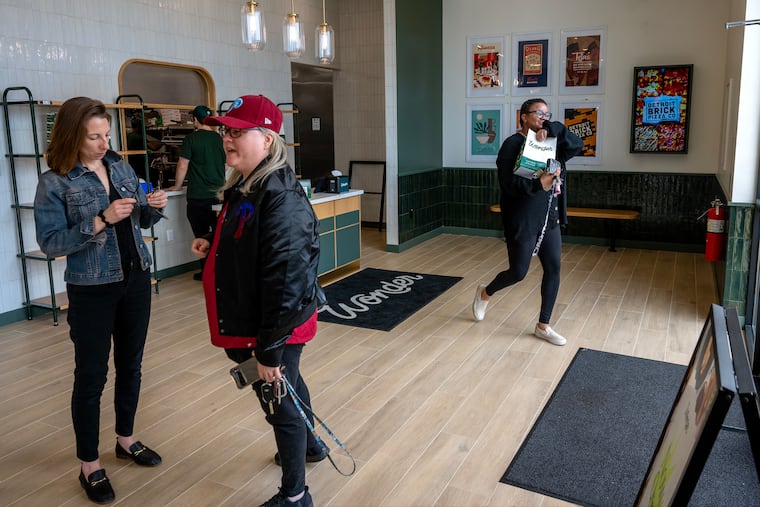 Aiyana Jones (right), who works in Cherry Hill, leaves with her take-out lunch ordered at Wonder Food Hall in the Garden State Park shopping center.
