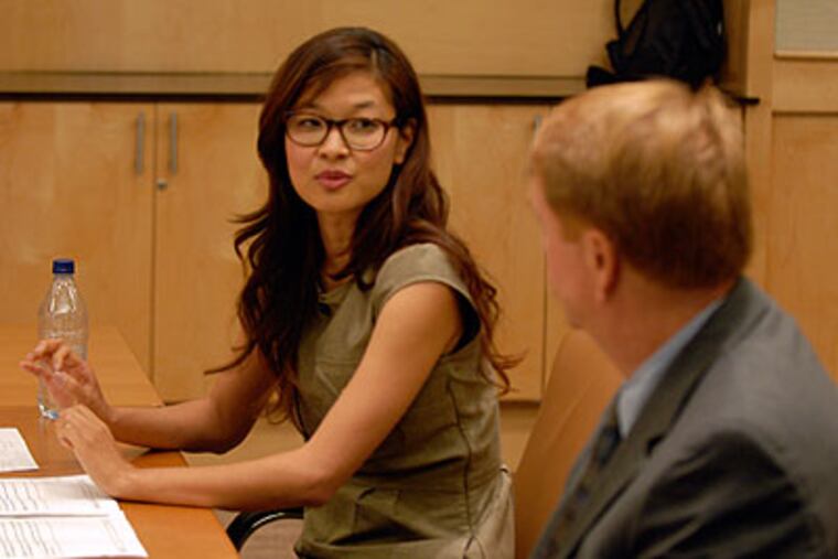 Sue Chinpak talks with Penn State professor Michael Hogan as they moderate a debate on immigration during a five-state videoconference from the National Constitution Center. (Ron Tarver / Staff Photographer)