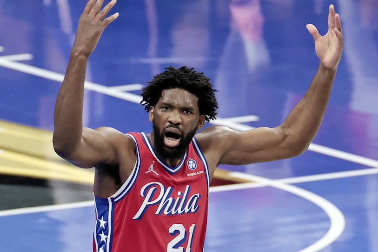 The Sixers' Joel Embiid tries to hype fans up in the second half vs. the Boston Celtics on Friday. He played significant minutes down the stretch of the Sixers' first loss of the season.