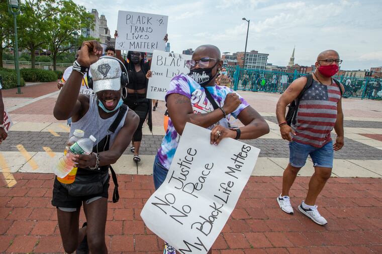 Rasean Lopez (left) and Aminha Howell (center) break into dance upon arriving at Penn’s Landing for celebration after the “Black Queer Lives Matter” rally on Saturday.