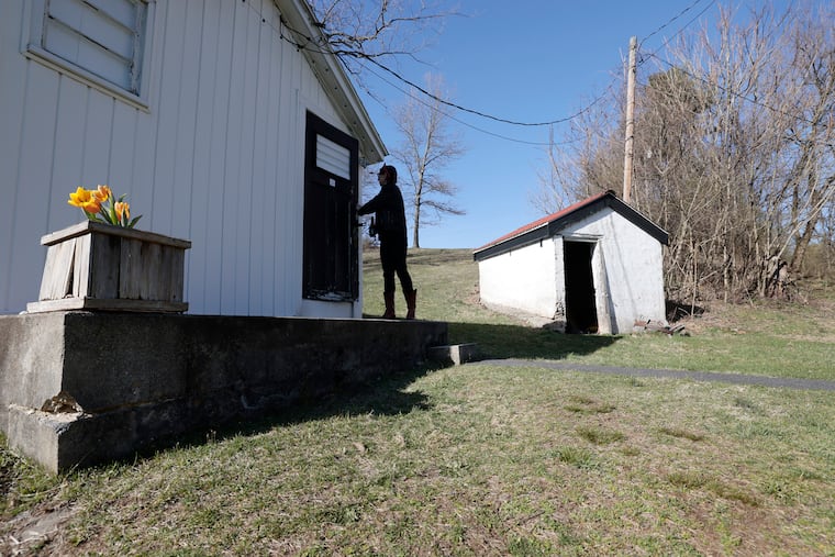 A guest walks out of artist Lance Rautzhan’s “cabin collective” gallery in Pottsville, Pa. on April 2, 2023.