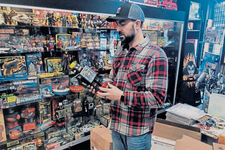 Jermy Fairgrieve, owner of Pop Culture Connections in Greensburg, packs a Buck Rogers Atomic Pistol toy made in the 1930s.