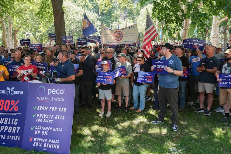 Jim McGill (left), business agent with IBEW Local 614, speaks with workers and union representatives who gathered in Washington Square Park for an update on negotiations with Peco last month.