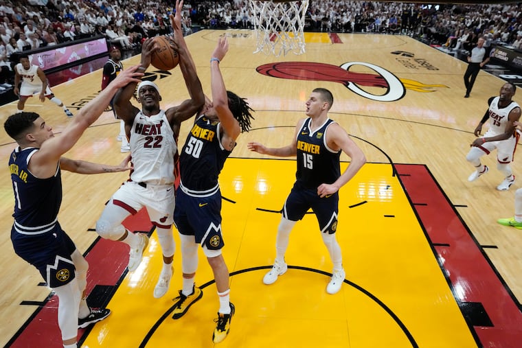 The Heat's Jimmy Butler goes to the basket against the Nuggets' Aaron Gordon, Nikola Jokic and Michael Porter Jr. during Game 4 of the NBA Finals on Friday.