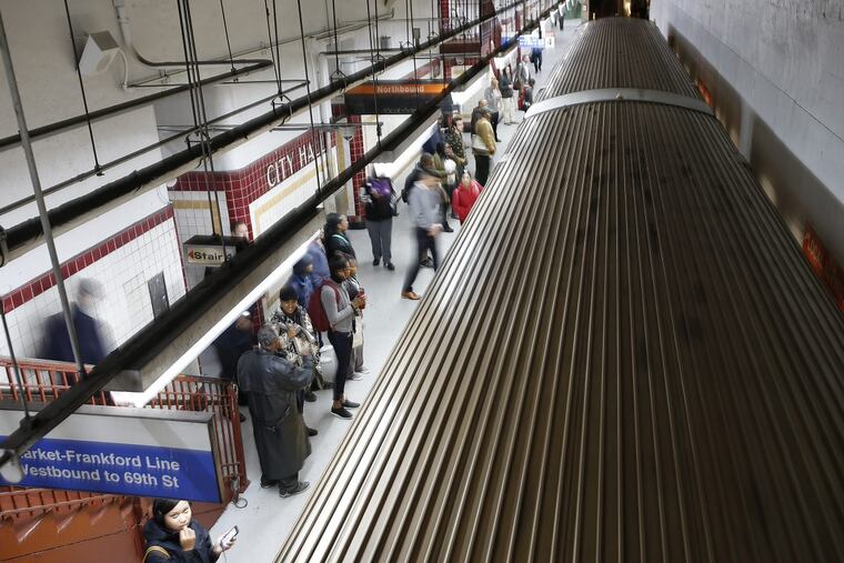 Commuters wait for the Broad Street line train at City Hall station.