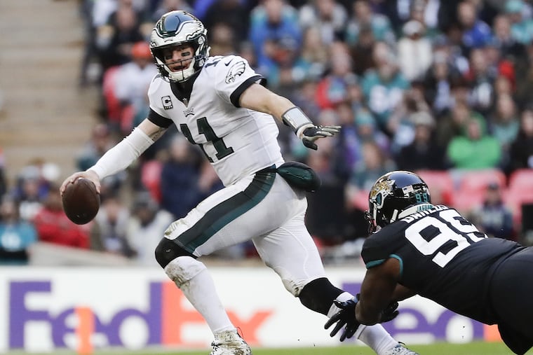Carson Wentz runs past Jaguars defensive tackle Marcell Dareus during a fourth-quarter scramble at Wembley Stadium.