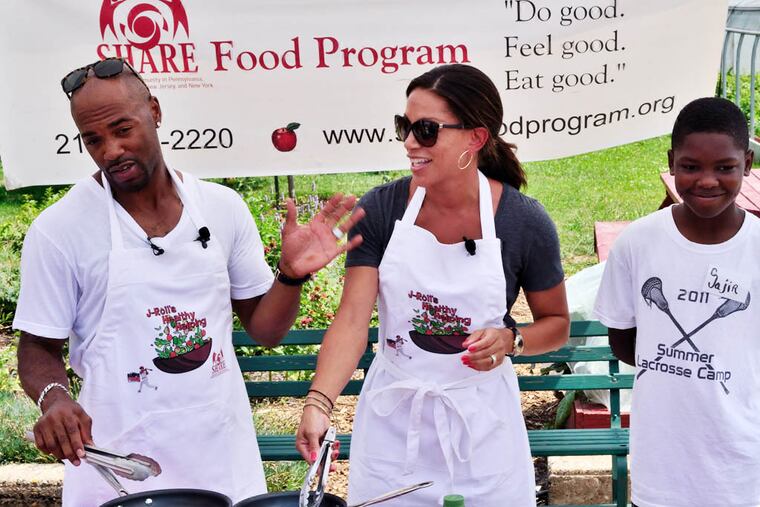 Jimmy Rollins shares jokes with the crowd while sharing some of his healthy cooking tips with his wife, Johari, and one of the program's long time volunteers, Sajir, on Wednesday, July 23, 2014. C.F. Sanchez / Staff Photographer