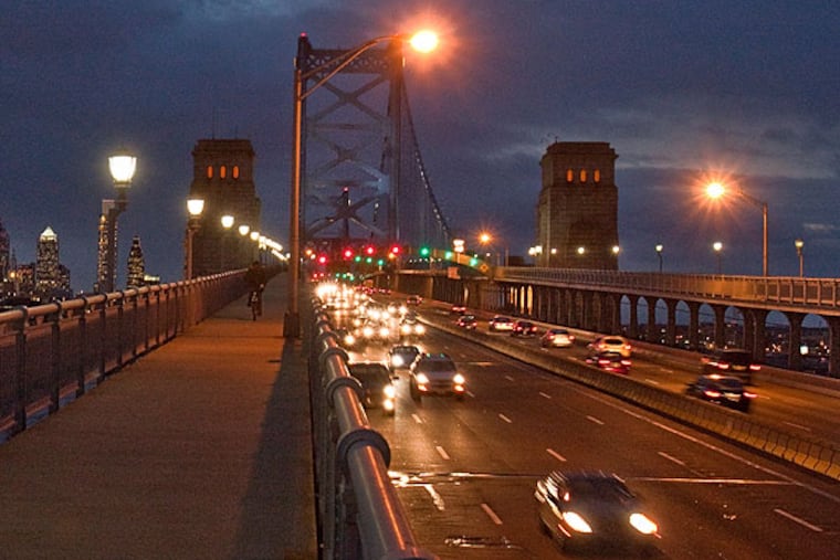 Vehicles traveling to New Jersey at dusk (headlights on left side) on the Ben Franklin Bridge. (David M Warren / Staff Photographer)