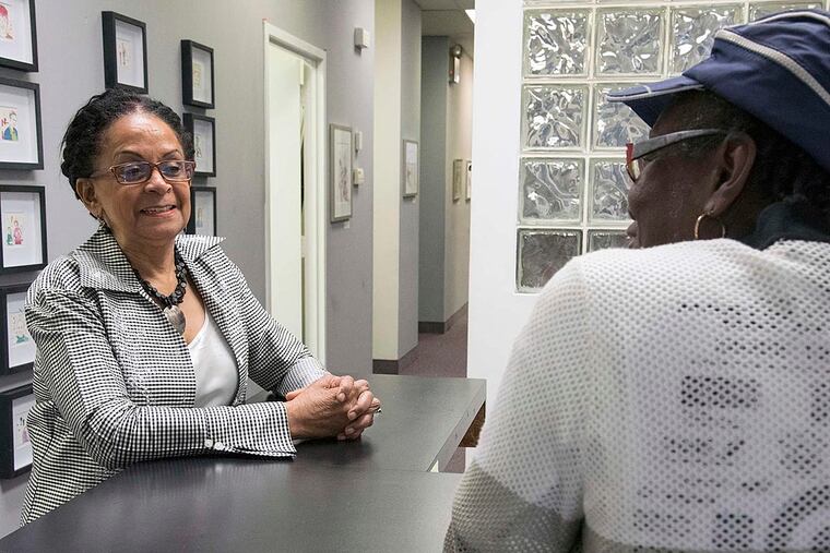 Mary Livingston, 64, president of SCORE Philadelphia (left), listens to Annette Hall discuss what her organization does and how SCORE has helped develop her business.