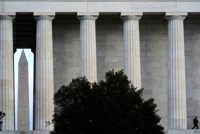 A National Guardsman walks along the Lincoln Memorial as the Washington Memorial looms in the background as security measures are heightened ahead of President-elect Joe Biden's inauguration ceremony.