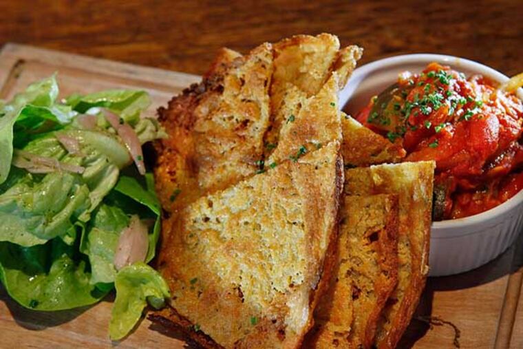 The Provencal socca - a crepe of chickpea flour and olive oil - is served with a crock of ratatouille and a mound of Bibb lettuce at the Good King Tavern.