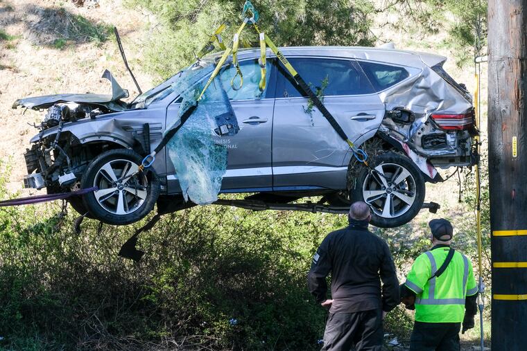 In this Feb. 23 photo, a crane is used to lift a vehicle after a rollover accident involving golfer Tiger Woods, in the Rancho Palos Verdes suburb of Los Angeles.