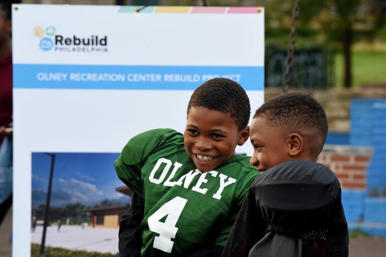 Olney Eagles youth football players watch during ceremonies at their rec center. Work will begin this month to build a turf field, as well as and outdoor track, new playgrounds, a new rec center building, and other upgrades