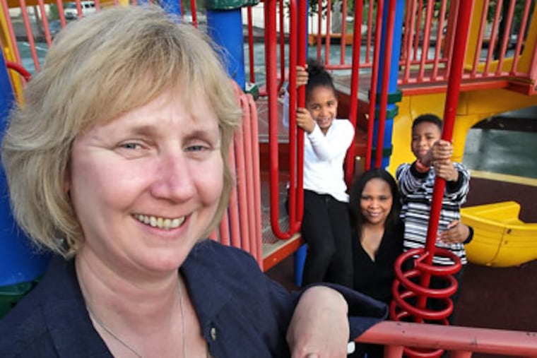 Irene Madrak, left has been with the North Light Community Center in
Manayunk for 30 years, serving families like Chanel Broadus, center
background and her children Bryce, 8, right and Jade, 6, left. (Steven M. Falk / Staff Photographer)