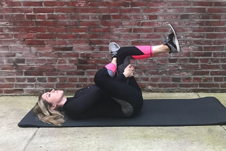 Ashley demonstrates a supine figure 4 stretch in this 2017 file photo.