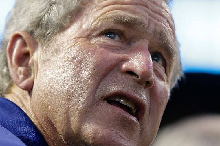 Former President George W. Bush sits in the stands during a baseball game between the Baltimore Orioles and Texas Rangers Friday, July 19, 2013, in Arlington, Texas. (AP Photo/LM Otero )