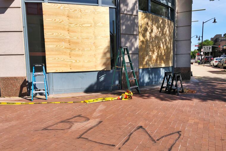 Workers boarded up the windows on a building in downtown Trenton that houses businesses as well as state government offices.