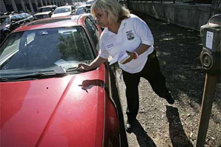 Hilda Bielecki of the Philadelphia Parking Authority tickets a car last year. The television series 'Parking Wars' is beginning to pay dividends for the city. (File photo)