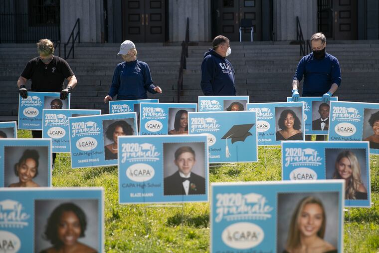 Teachers and staff at the Philadelphia High School for Creative and Performing Arts (CAPA) install signs with the photos and names of their graduating class of 2020 in front of the school as a surprise for the students. Students will eventually be able to pick up the signs at a later date when they receive their diplomas.