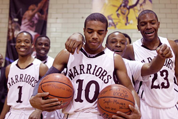 Boys' Latin's Maurice Watson Jr. is surrounded by teammates as he holds basketballs marking his 1,000th and 2,000th career points. He scored 22 points in an 80-59 win over Gratz. (Michael S. Wirtz / Staff Photographer)