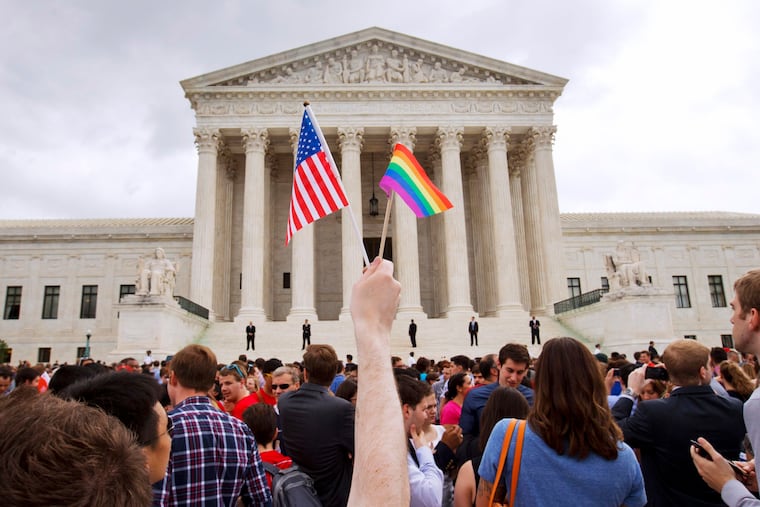 A man holds a U.S. and a rainbow flag outside the Supreme Court in Washington after the court legalized gay marriage nationwide in 2015.