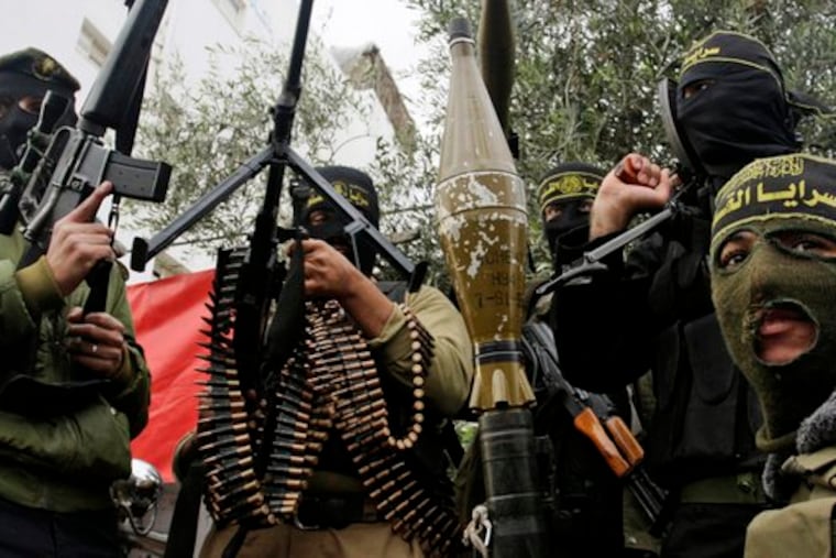 Palestinian extremists display their weapons during a rally in the central Gaza Strip. None of Gaza's factions claimed responsibility for yesterday's deadly attack, which also injured three.