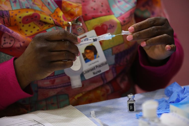 A health-care worker prepares a vaccine dose at a community COVID-19 vaccination clinic in West Philadelphia in February.