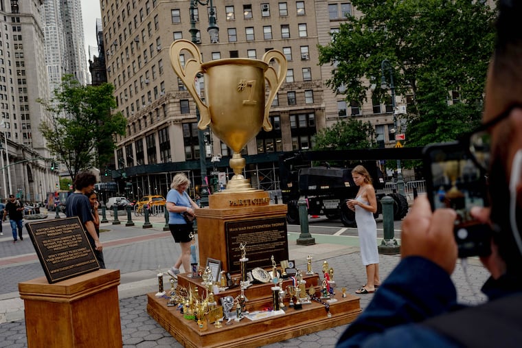 Passersby examine the Secret Handshake's “Iran War Participation Trophy” installation on Wednesday in New York's Foley Square.