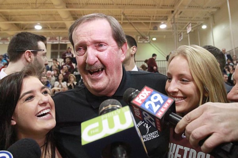 Philadelphia University's Herb Magee is hugged by his granddaughters, Karly Stec (left) and Katie Stec (right) after his 1,000th career win. (Charles Fox/Staff Photographer)