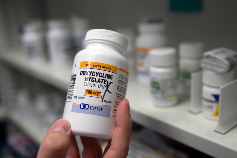A pharmacist holds a bottle of the antibiotic doxycycline hyclate in Sacramento, Calif., July 8, 2016.