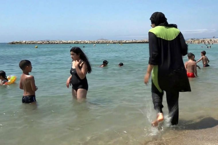 A woman gets into the sea wearing a burkini at Marseille in southern France.