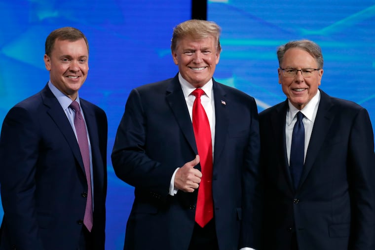 President Donald Trump in April poses with NRA-ILA Executive Director Chris Cox (left) and executive Vice President Wayne LaPierre before speaking at the National Rifle Association Institute for Legislative Action Leadership Forum in Lucas Oil Stadium in Indianapolis. The president has abandoned the idea of releasing proposals to combat gun violence that his White House debated for months following mass shootings in August.