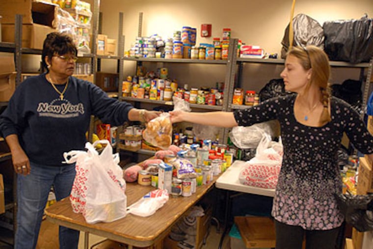 Gerri Harvie, a long-time volunteer of Fresh Start Emergency Food and Resources Services, and volunteer Anna Vornholt pack bags for clients in the store room of the pantry. (Ron Tarver / Staff Photographer)