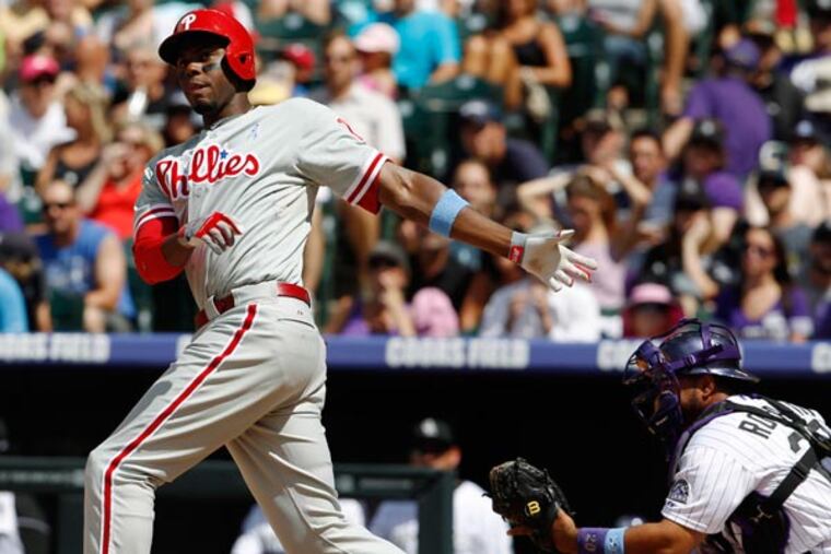 John Mayberry (left) follows the flight of his bat after he missed a pitch while swinging as Colorado Rockies catcher Wilin Rosario fields the pitch in the fifth inning of a baseball game in Denver on Sunday, June 16, 2013. (David Zalubowski/AP)