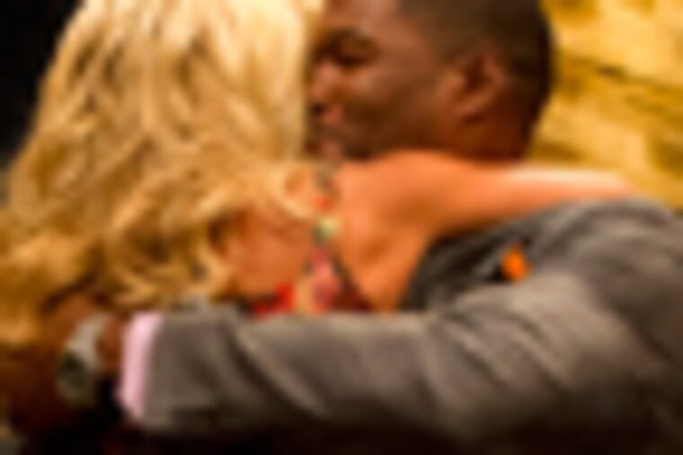 Former football player Michael Strahan, right, greets Kelly Ripa on the set of the newly named "Live! with Kelly and Michael" on Tuesday, Sept. 4, 2012 in New York. Strahan joined the popular morning show as a permanent co-host on Tuesday, fulfilling a joking prophecy he made to Regis Philbin more than four years ago. The gap-toothed former New York Giant jogged onto the morning show set and picked up co-host Kelly Ripa in a bear hug, lifting her off her feet. He replaces Philbin, who left last November. Strahan was the survivor in a series of on-air tryouts of potential co-hosts since Philbin left, and his hiring has been an open secret for the past two weeks. (Photo by Charles Sykes/Invision/AP Images)