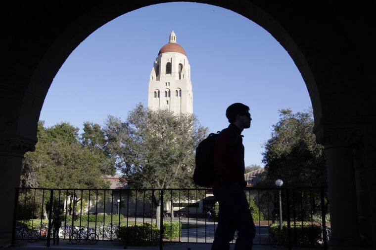 A Stanford University student walks in front of Hoover Tower on the campus in Palo Alto, Calif.
