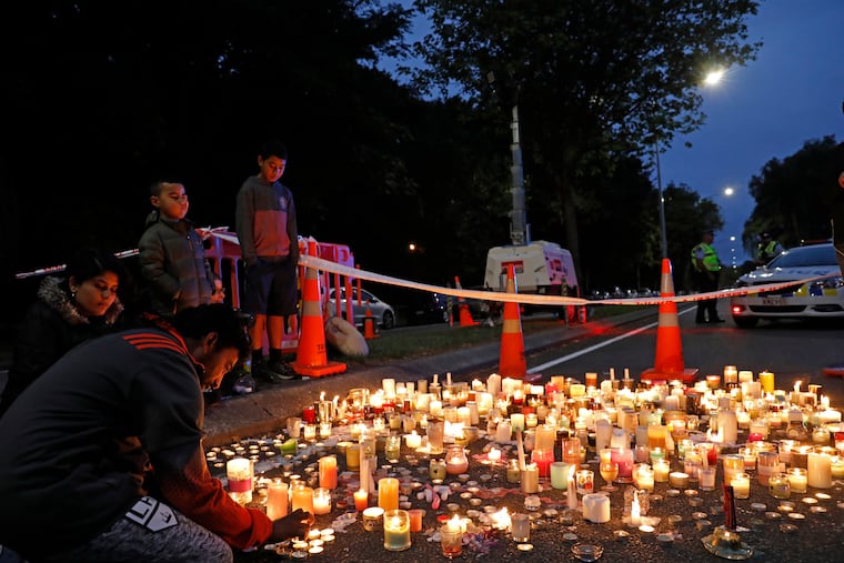 A mourner lights a candle during a vigil to commemorate victims of Friday's shooting, outside the Al Noor mosque in Christchurch, New Zealand, Monday, March 18, 2019. Three days after Friday's attack, New Zealand's deadliest shooting in modern history, relatives were anxiously waiting for word on when they can bury their loved ones.