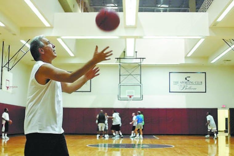 Waiting to get back on the court, John Branigan, 57, of Voorhees, warms up at the Sporting Club.
