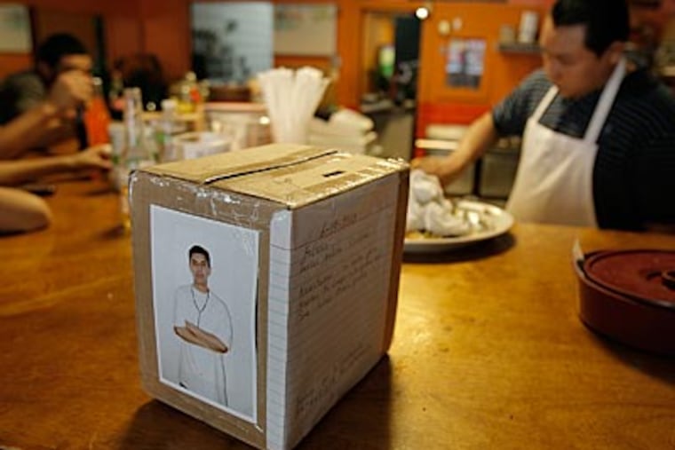 A picture of Javier Medina is pasted on a donation box on the counter of La Toca Loca Restaurant. (Akira Suwa / Staff Photographer)