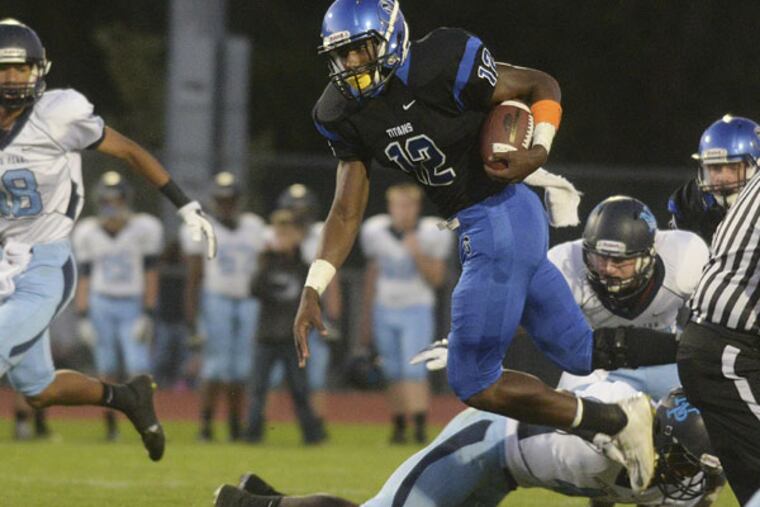 Central Bucks South's Josh Adams runs over the top of North Penn defenders. (BOB WILLIAMS / For the Inquirer)
