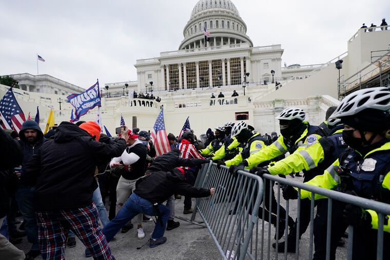 Rioters supporting President Donald Trump try to break through a police barrier at the Capitol in Washington, on Jan. 6, 2021.