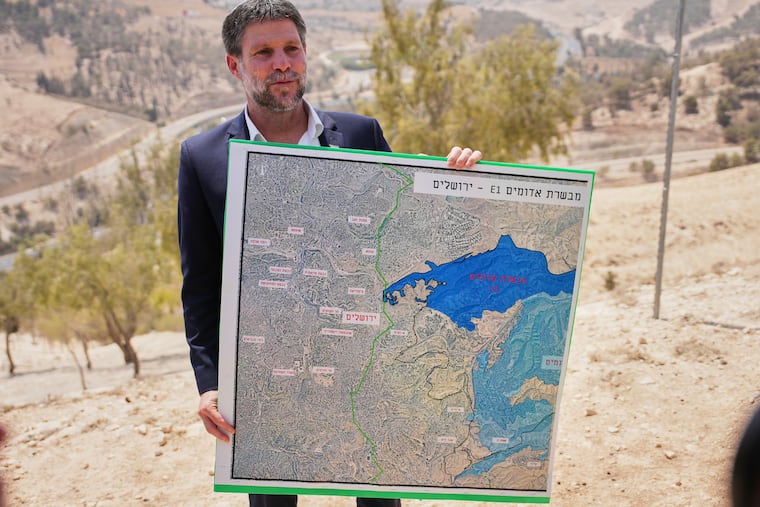 FILE - Israeli Finance Minister Bezalel Smotrich holds a map that shows the E1 settlement project during a press conference near the settlement of Maale Adumim, in the Israeli-occupied West Bank, Aug. 14, 2025. (AP Photo/Ohad Zwigenberg, File)