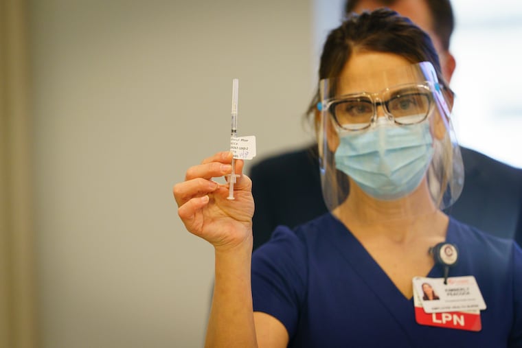 LPN Kimberly Peacock holds a dose of the COVID-19 vaccine at Cooper University Health Care, in Camden, on Dec. 15.