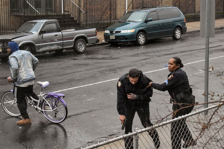 In this Dec. 10, 2019 photo, Jersey City police Sgt. Marjorie Jordan, right, helps fellow officer Raymond Sanchez to safety after he was shot during a gunfight that left multiple dead in Jersey City, N.J. The two killers were armed with a variety of weapons, including an AR-15-style rifle and a shotgun that they were wielding when they stormed into a store in an attack that left the scene littered with several hundred shell casings, broken glass and a community in mourning. Despite years of New Jersey officials focusing on the problems of crime guns coming into the state, Tuesday's shooting shows efforts are falling short.