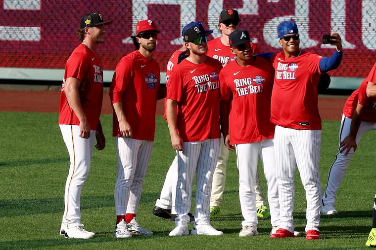 New York Mets' Juan Soto (right) takes a selfie with some of his fellow National League All Stars, including Phillies' slugger Bryce Harper during batting practice in Philadelphia Monday